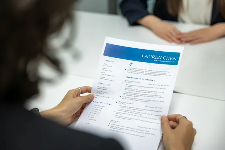 a woman is reading a resume at a table